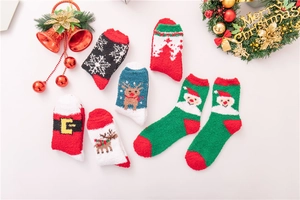 Makroansicht flauschiger Weihnachts-Korallenfleece-Socken mit Rentier- und Schneeflockenmustern