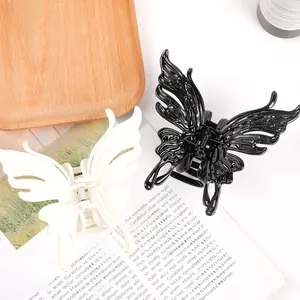Macro shot of large butterfly hair claws in black and cream with detailed wing texture