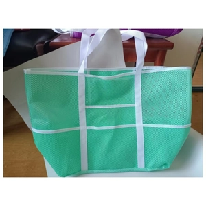 Sac de plage en maille verte avec poignées blanches et poches de rangement multiples