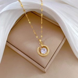 Luxurious gold-plated moon necklace with sparkling zircons on a beige jewelry box