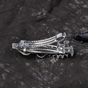 Detail view of the spring clip mechanism on a gothic silver skull bat hair clip