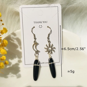 Detail of bohemian sun and moon earrings with black stone drops and wire wrap detail