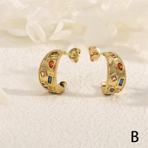 Macro shot of gold vintage C-shaped earrings with colorful multi-gemstones and beaded edges