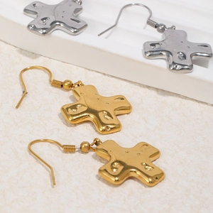 Détails de boucles d'oreilles croix or et argent avec fini martelé et crochets de style poisson