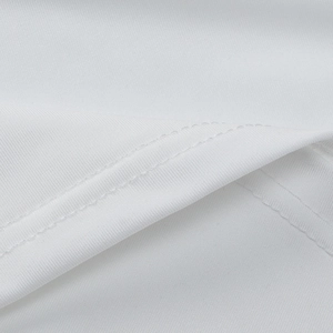 Macro detail of high-quality double-needle stitching on white knit dress fabric