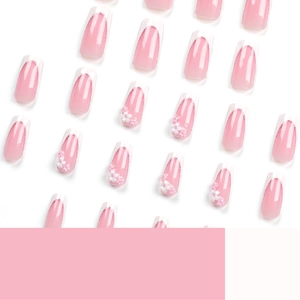 Pink gradient press-on nails with white French tips, 3D floral accents, and fine glitter