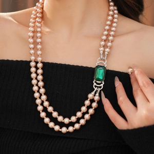 Dettaglio collana di perle champagne a doppio filo con ciondolo gemma verde taglio smeraldo