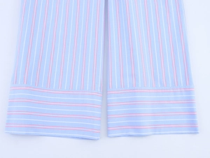 Detail of blue and red striped woven fabric showing precise stitching on the cuff
