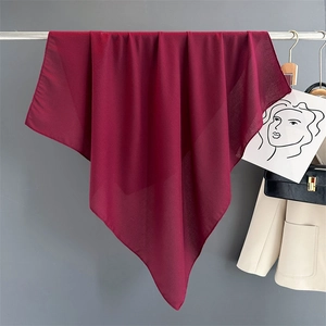 Detail view of wine red cotton linen scarf draped elegantly on a metal hanger