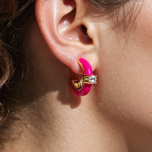 Pink enamel C-shaped earrings with round zircon inlay shown on model's ear lobe