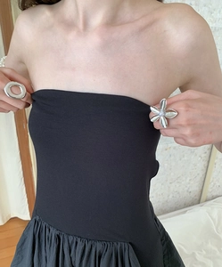 Close-up of a silver floral pearl ring and hollow circular ring on a model in black dress