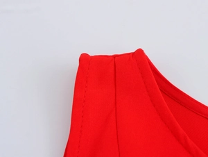 Close-up of red bubble dress shoulder detail showing neat stitching and woven texture