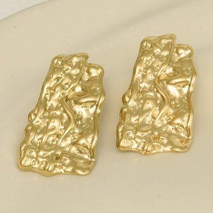 Macro detail of 18k gold plated stainless steel earrings with irregular lava texture