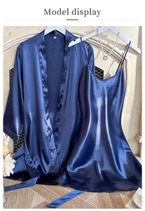 Detail of navy blue silk satin bathrobe and nightgown set hanging on a rack indoors