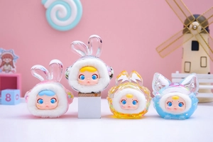 Detail of four colorful resin figurines with glitter ears in a pastel candy land setting