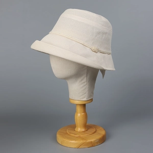 Beige Japanese paper sun hat with pearl beads and floral detail on a wooden stand
