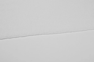 Detail view of white ice silk knit fabric showing fine vertical texture and neat edge stitching