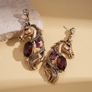 Macro view of vintage horse head earrings with red faceted gemstone and rhinestones