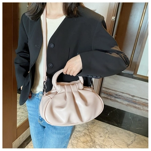 Detailed view of pink pleated cloud bag with soft leather texture and detachable strap