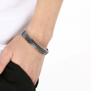 Detail view of vintage Viking Valknut cuff bracelet with Celtic knot patterns on wrist