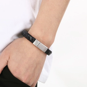 Close-up of men's black braided leather bracelet with silver brushed magnetic clasp on wrist