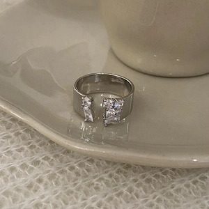 Detail of adjustable silver ring with multi-shape cubic zirconia on ceramic tray
