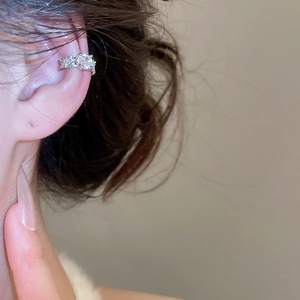 Macro view of silver cubic zirconia ear cuff on ear without piercing for women