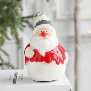 Figurine de Père Noël en céramique sur un livre blanc avec décor de Noël et bokeh chaud