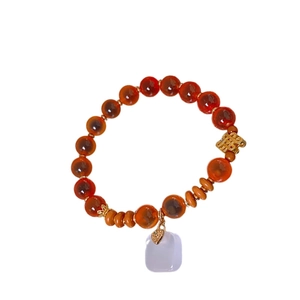 Elegant Chinese style bracelet with red agate beads and golden knot charm in minimalist view