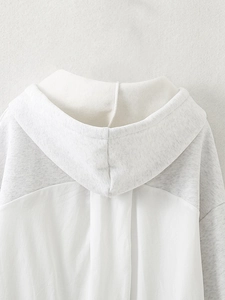 Detail of the hooded neckline and contrast stitching on white and grey hoodie