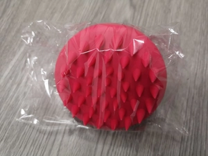 Detail of soft rose red silicone scalp massager brush in its protective transparent packaging