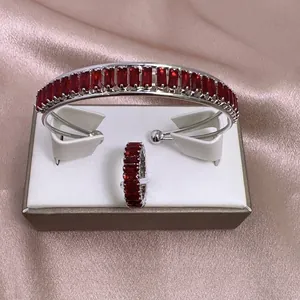 Detalle de set de joyería de lujo con circón rojo y cristales sobre satén rosa