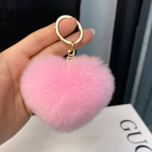 Close-up of fluffy pink heart-shaped faux rabbit fur keychain with gold ring