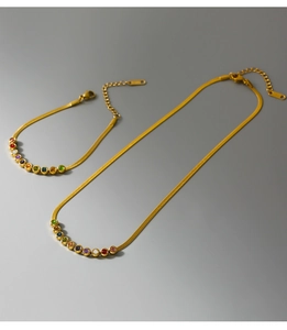 Detail of gold snake chain necklace and bracelet set with colorful round zircon stones