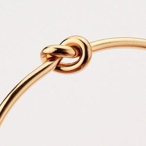 Polished gold titanium steel knot bracelet with minimalist heart-knot opening design