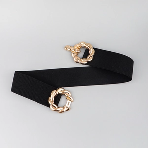 Detail of black elastic waist belt featuring golden woven interlocking buckle rings