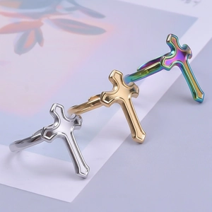 Macro detail of cross design rings in polished silver, gold, and iridescent finishes