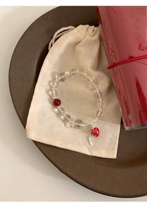 Close-up of glass beaded strawberry bracelet with S925 silver tag and flower charm