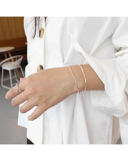 Detail of minimalist double-layer S925 sterling silver chain bracelet and cross ring set
