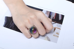 Macro detail of silver stainless steel ring with colorful foil glass stone on model hand