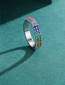 Macro shot of silver ring with rainbow pavé setting and multi-colored gemstones