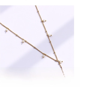Close-up of gold-plated titanium steel chain featuring delicate white pearls