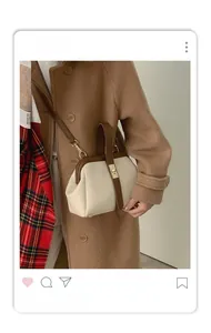 Detail of retro doctor bag with cream and brown color-blocking and metal clasp