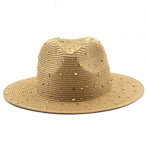 Close-up of khaki straw fedora with shimmering golden rhinestone studs detailing