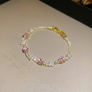 Elegant gold tennis bracelet with square pink zircons and white crystals on leather