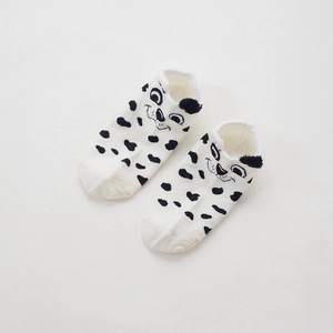 Close-up of white cotton socks with black spots and 3D ears featuring a Dalmatian dog