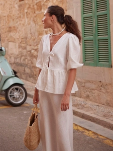 Detail of white cotton two-piece set featuring V-neck tie-front top and long skirt