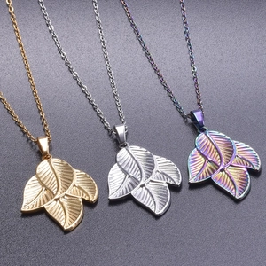 Detailed macro view of leaf pendants in gold, silver, and rainbow 18k plated finishes
