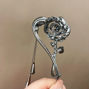 Détail pince à cheveux rose argentée avec longue chaîne à pompon et pendentif