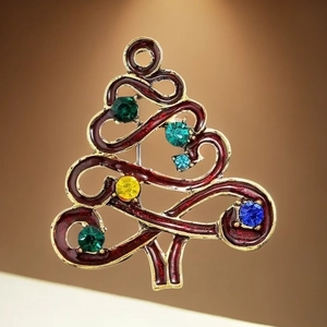 Broche sapin de Noël rouge foncé avec bordure dorée et strass colorés sur fond dégradé